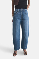 Jeans van midblauw denim van MANGO, wijd model, gecombineerd met zwarte top en sandalen met bandjes.