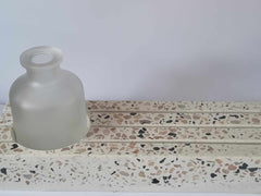 Terrazzo kaarthouder met structuur en wit vaasje