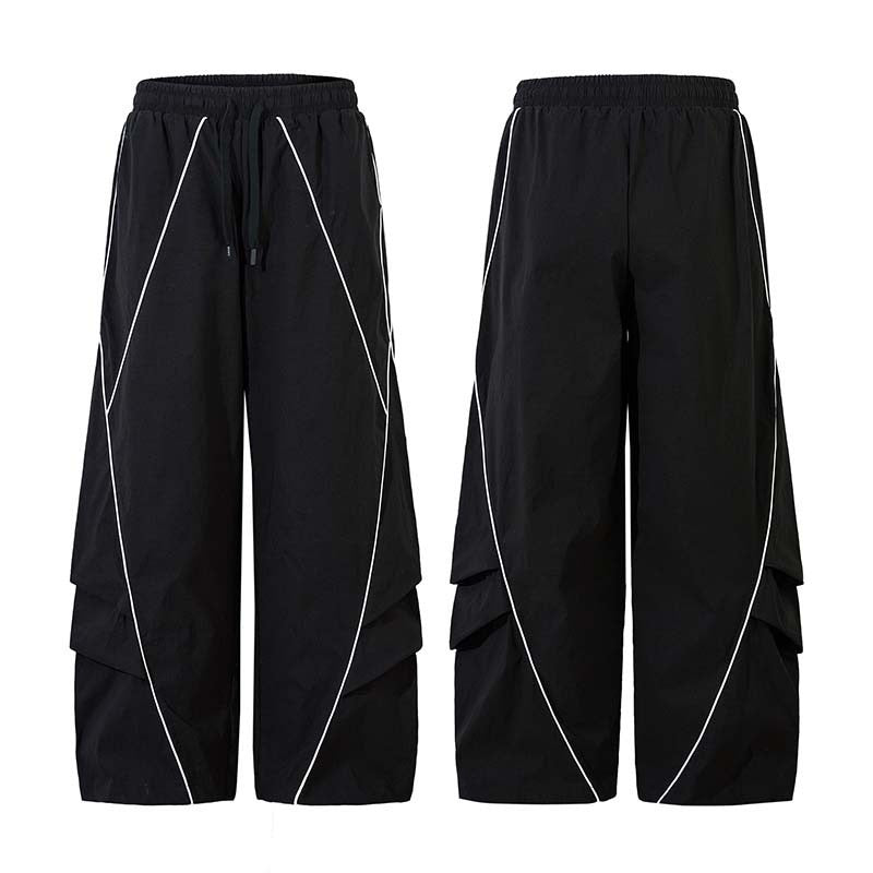 Black wide-leg track pants with white reflective curved line detailing, shown front and back view on white background
