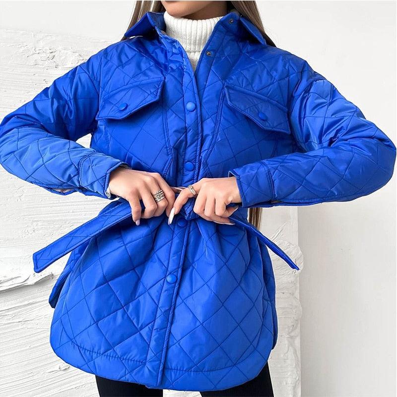 Frau in blauer Steppjacke mit Gürtel, Wintermode, Damenbekleidung, Outdoorjacke.