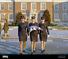 Three female Marines, in dress blue uniforms, raise the morning colors. First view in a series of three Stock Photo